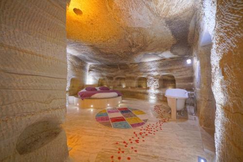 a room with a bed in a stone building at Göreme Cave Lodge in Goreme