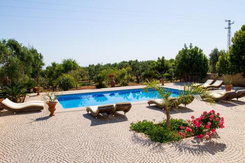 a swimming pool with chaises and chairs in a resort at Villa Vanessa in Leuca