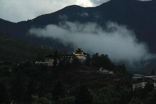 a house on top of a hill with a mountain at Khamsum Inn in Thimphu