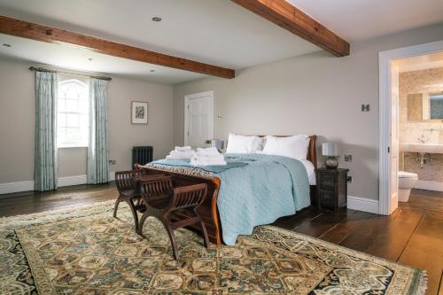 a bedroom with a bed and a table with two chairs at Heron House at Millfields Farm Cottages in Hognaston