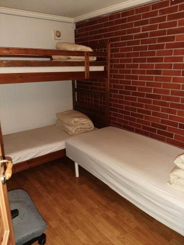 two bunk beds in a room with a brick wall at Gardenview Room in Madla