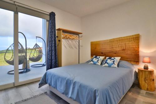 1 dormitorio con cama y ventana grande en Casa Baleia a Vista, en Algarvia