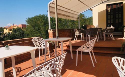a patio area with chairs, tables and umbrellas at Villa Lavinia B&B in Montescudaio