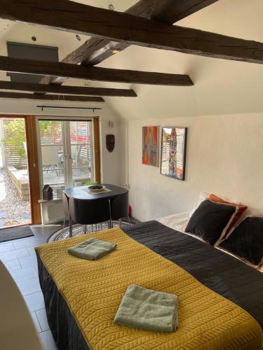 a bedroom with a large bed with a yellow blanket at Logisolkatten in Veberöd