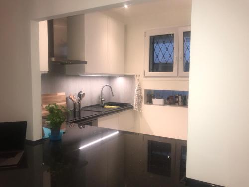 une cuisine avec des armoires blanches et un comptoir noir dans l'établissement La Rotonde, à Cannes