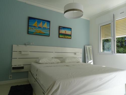 une chambre blanche avec un lit et une fenêtre dans l'établissement La Rotonde, à Cannes