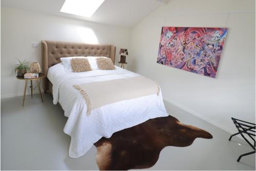 een slaapkamer met een bed en een schilderij aan de muur bij Louis Henry Loft in Londerzeel