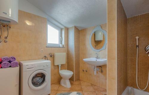 a bathroom with a washing machine and a sink at Apartments Topalović in Kostrena