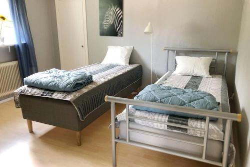 duas camas sentadas uma ao lado da outra num quarto em Egen lägenhet i 2-familjshus på landet. em Tierp