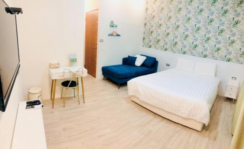 台東市的住宿－小院子4人至6人包棟民宿，一间卧室配有一张床和一张蓝色的沙发