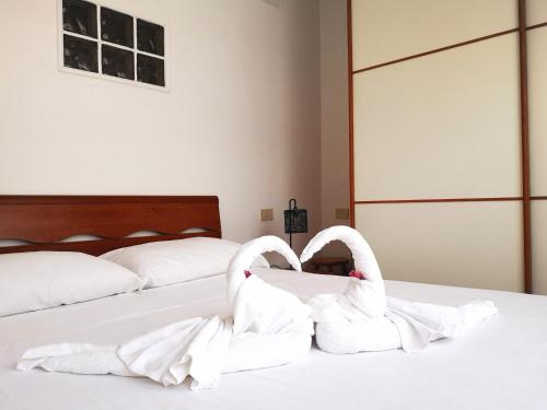 Deux cygnes blancs sont assis sur un lit dans l'établissement Appartamento Jungle Beach, à Lido di Ostia