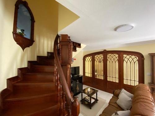 a living room with a staircase and a couch at Alojamento dos Oleiros in Vila Franca do Campo