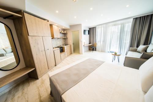 a room with a bed and a living room with a couch at Kali Thea Suites in Neos Marmaras