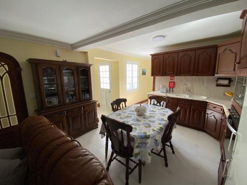a kitchen with a table with a table cloth on it at Alojamento dos Oleiros in Vila Franca do Campo