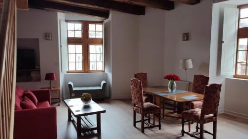uma sala de estar com mesa e cadeiras em Salardine Apartments - Duplex with Modern Touch em Châlus
