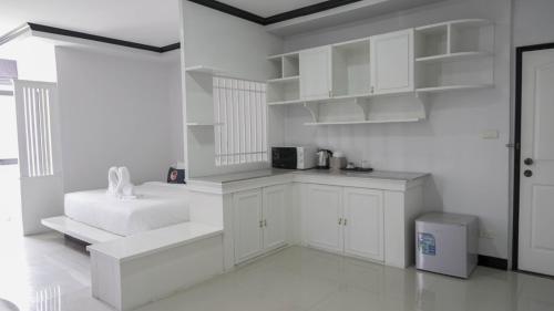 cocina blanca con armarios blancos y microondas en RoomQuest Nichada ISB International en Ban Bang Talat