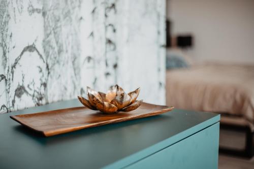 a bowl on a wooden plate on a table at Joy Aparthotel Keilberg in Klínovec