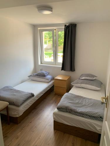 pokój z 3 łóżkami i oknem w obiekcie Sajó Vendégház w mieście Sajószöged