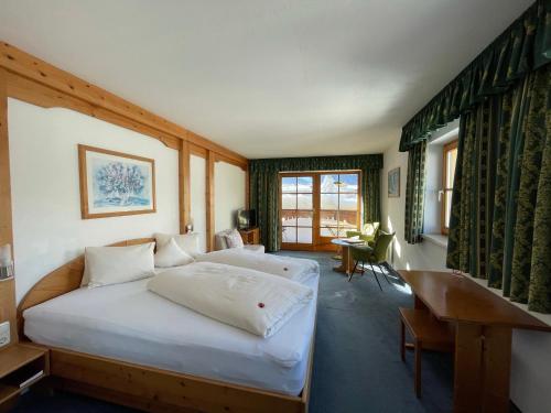Hotel Alpin في ايروالد: غرفة نوم بسريرين ومكتب فيها