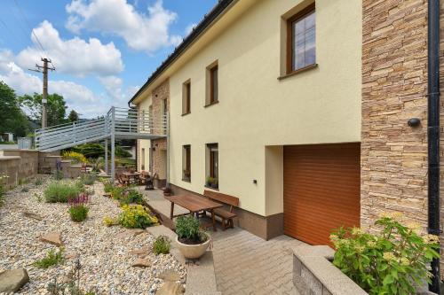 a house with a wooden garage door and a patio at Joy Aparthotel Keilberg in Klínovec