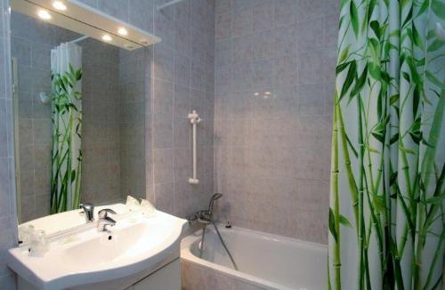 La salle de bains est pourvue d'un lavabo, d'une baignoire et d'un miroir. dans l'établissement Motel le Colibri, à Lucciana