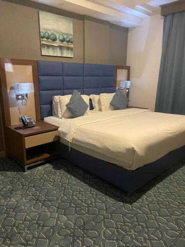 a hotel room with a large bed and a table at Swiss Blue Hotel Apartments in Jazan