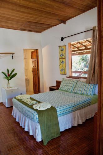 a bedroom with a bed and a window at Pousada Lawrence in Itacaré