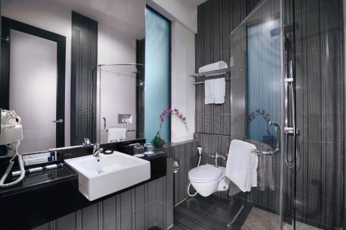 a bathroom with a sink and a toilet at Grand City Hall Hotel & Serviced Residences in Medan