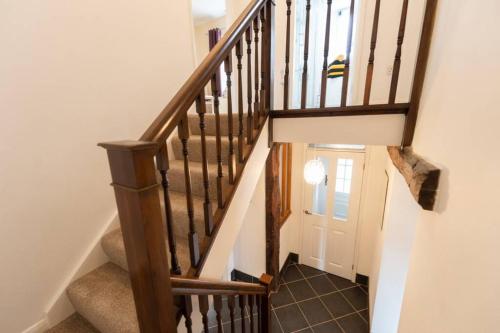 a stairway with a wooden stair case and a door at 2 Mews Cottages - Town Centre Location in Appleby