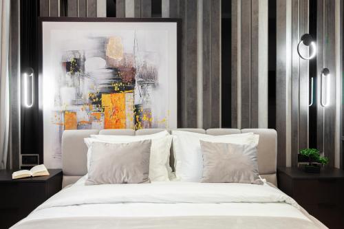 - une chambre avec un lit blanc et un tableau dans l'établissement Dream apartament on Drahomanova street, à Lviv