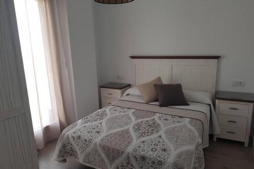 1 dormitorio con 1 cama, 2 mesitas de noche y ventana en CABRIA APARTMENT, en Granada