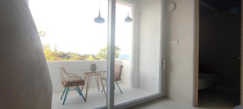 a room with a balcony with a table and chairs at Casa Mediterranea Jacuzzi vista Mare Torre Guaceto Ostuni in Specchiolla 