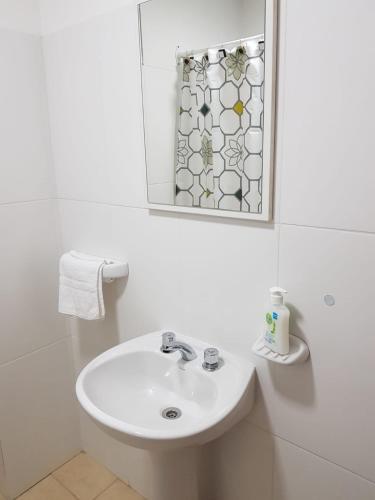 a white bathroom with a sink and a mirror at Alto Magallanes in Ushuaia