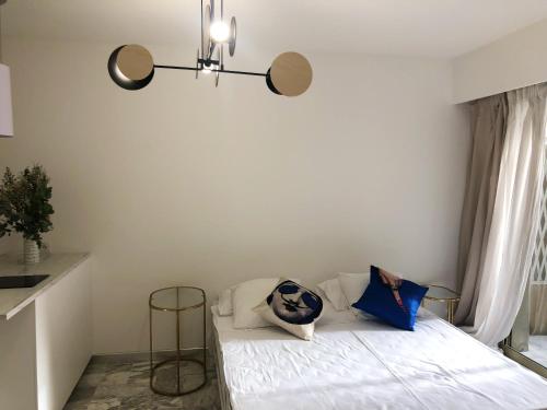 1 dormitorio con 1 cama con sábanas blancas y almohadas azules en Studio contemporain à Cannes avec terrasse et parking - 35 m², en Cannes