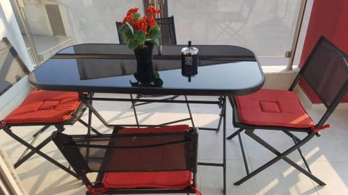 a table with a vase of flowers and two chairs at Perfect Suites in Neos Marmaras