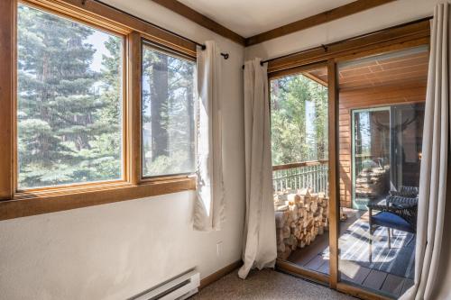 a room with windows and a balcony with a chair at Mountainback 15 in Old Mammoth