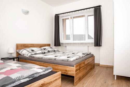 um quarto com 2 camas e uma janela em Apartmán v Žacléři Krkonoše em Zaclér