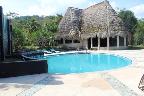 einem Pool vor einem Haus mit Strohdach in der Unterkunft Calico Jack's Resort in Sayab Camp