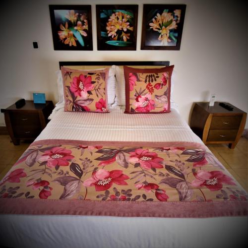 a bedroom with a bed with pink flowers on it at Amazilia Hotel in Pereira