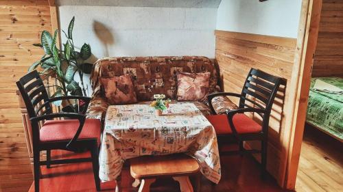 a dining room with a table and chairs and a couch at Woden apartment in Žabljak