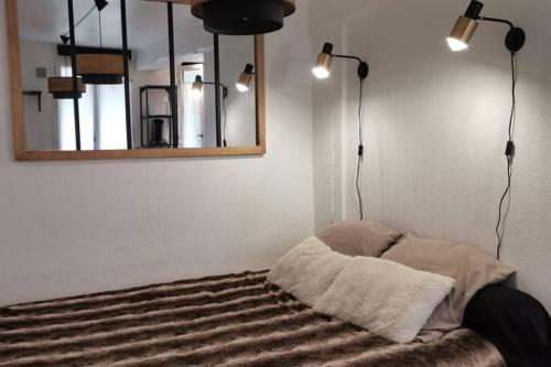 - une chambre avec un lit doté d'un miroir et de lumières dans l'établissement studio Nicaise, à Rouen