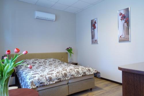 a bedroom with a bed and a table with flowers at Apartamenty w Ustce in Ustka