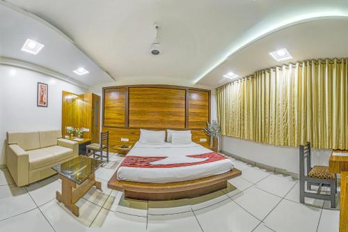 a bedroom with a bed and a couch and a chair at Hotel Radiant in Kolhapur