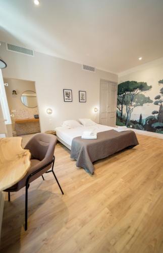 - une grande chambre avec un lit et une chaise dans l'établissement UNE HISTOIRE DE FAMILLE, à Collobrières