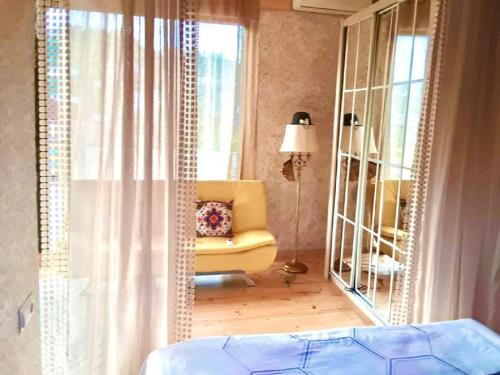 a bedroom with a yellow chair and a mirror at Batumi Wonderland in Batumi