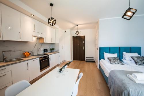 two beds in a small room with a kitchen at Drwinka Park Apartment in Krakow