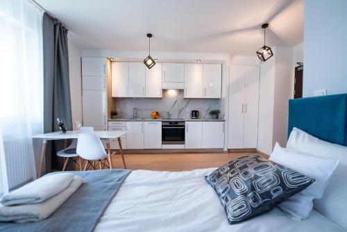 a bedroom with a bed and a kitchen with white cabinets at Drwinka Park Apartment in Krakow