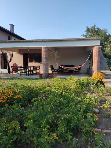 a house with a hammock on the back patio at Holiday home Dream Bosanska Krupa in Bosanska Krupa