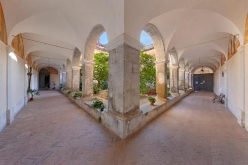 an empty hallway of an old building with arches at Relais il Chiostro Historic Courtyard & Panoramic Terrace near Sorrento in Massa Lubrense