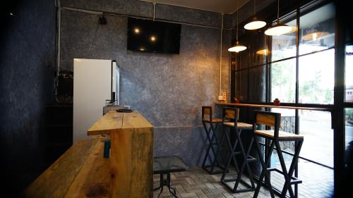 a bar with a wooden counter and stools in a room at Lala Hostel in Banda Aceh